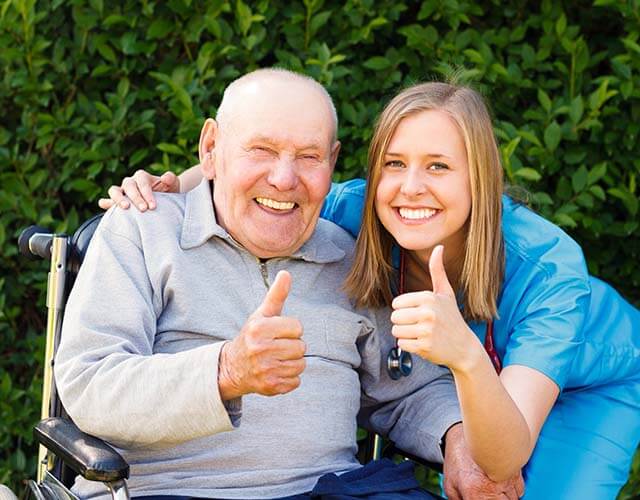 Old person and his caretaker showing thumbs up